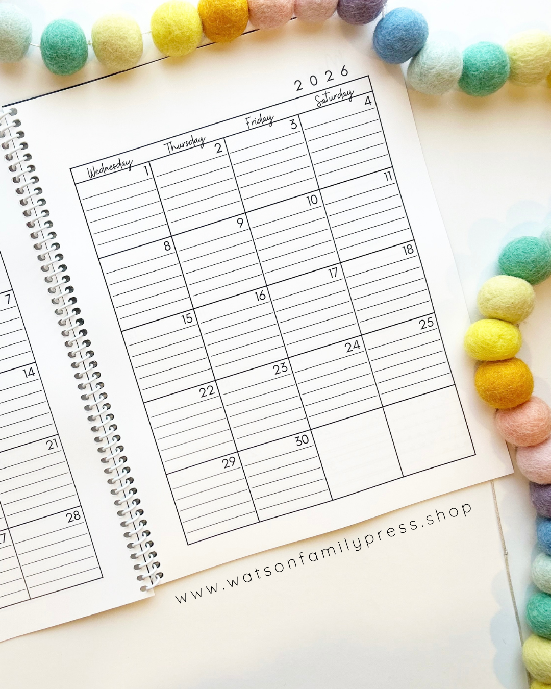 Open dated 2026 planner calendar page with a decorative border of colorful beads.